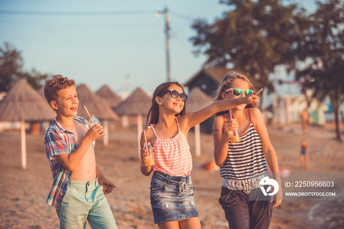 Portrait of happy children while having fun walking on the beach at the day time