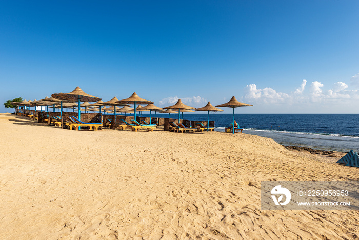 非洲埃及马萨阿拉姆附近的红海，带躺椅和草伞的沙滩