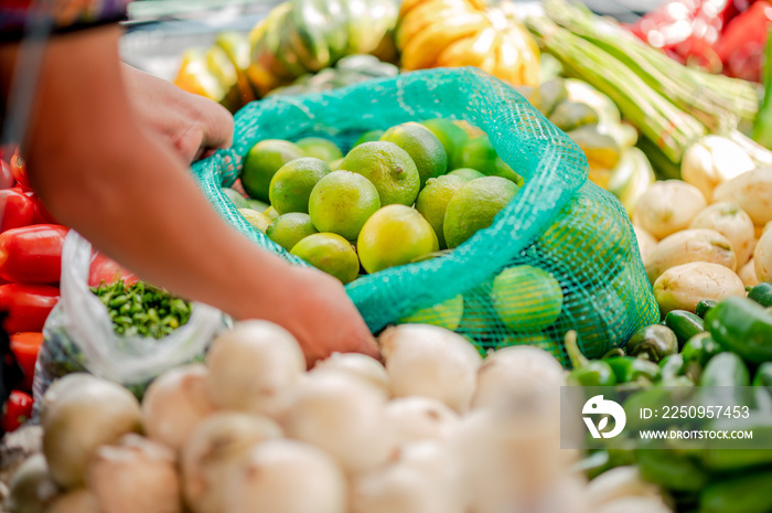 Manos de vendedora en un puesto de frutas y verduras. 