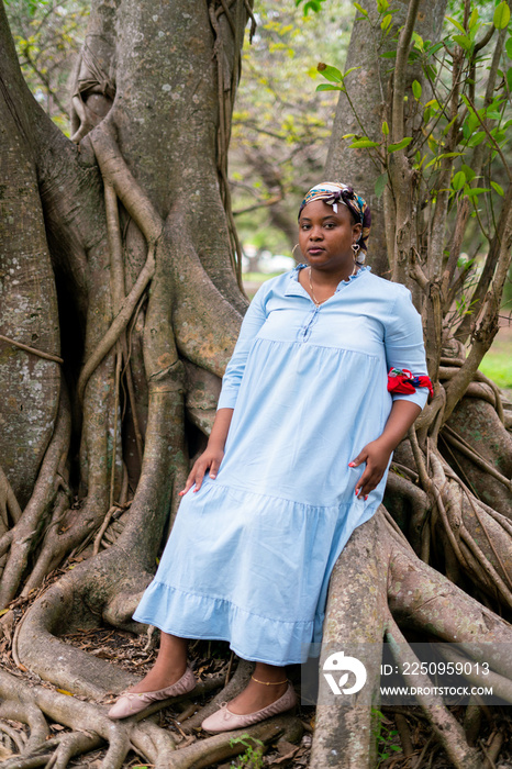 Haitian woman sitting in tree in traditional colors