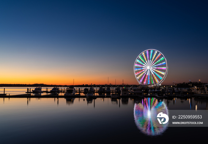 Illuminated ferris wheel at National Harbor near the nation capital of Washington DC at sunset