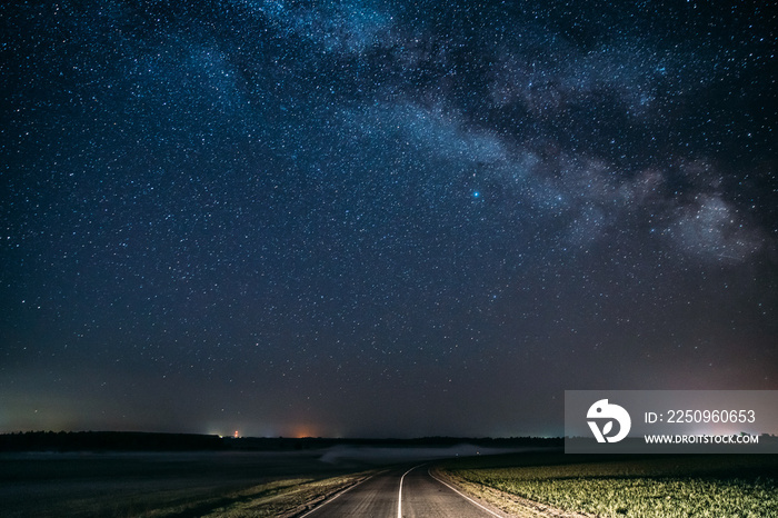 乡村和绿地的乡村沥青路上方的蓝夜星空。自然夜景