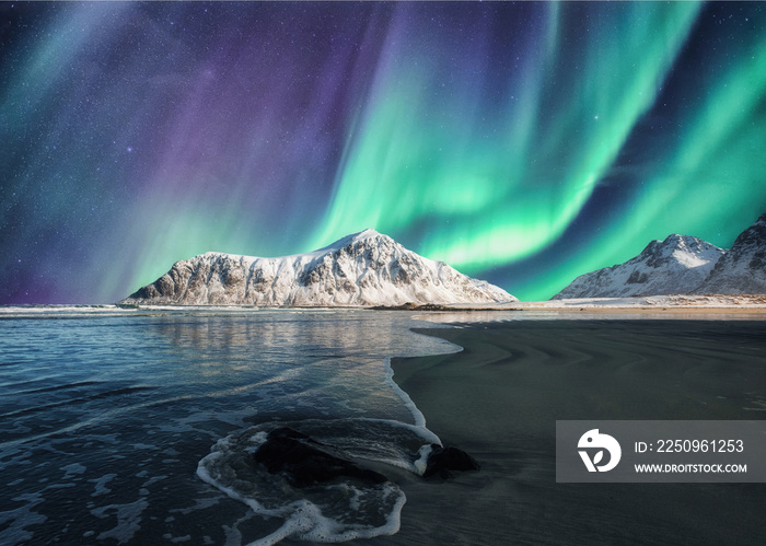 Aurora Borealis, Northern Lights Above on snowy mountain in Skagsanden Beach at Lofoten Islands