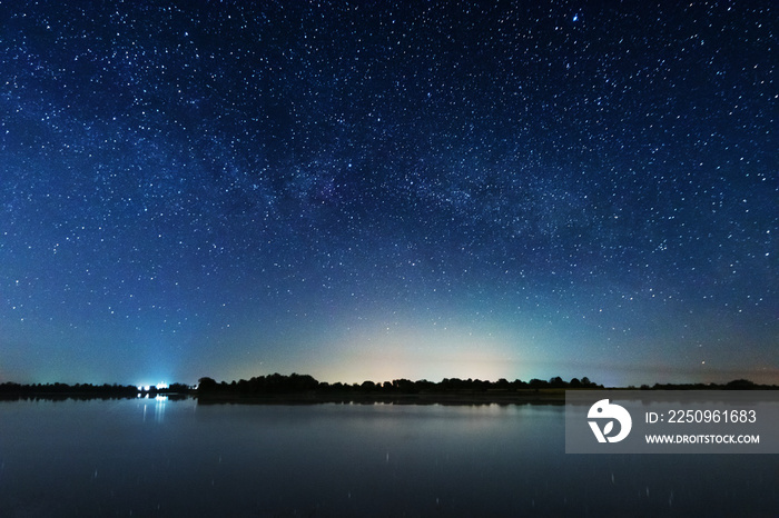 神奇的星夜与银河系在一棵大树的河边。