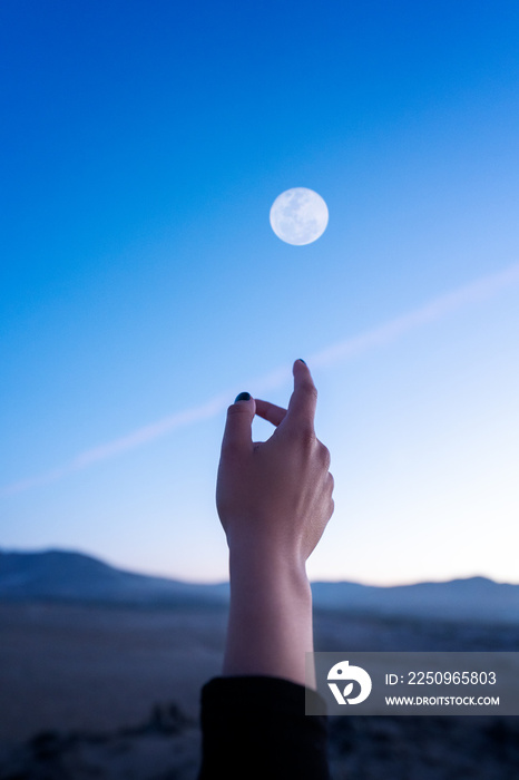 手视图，手指向或触摸天空和月亮