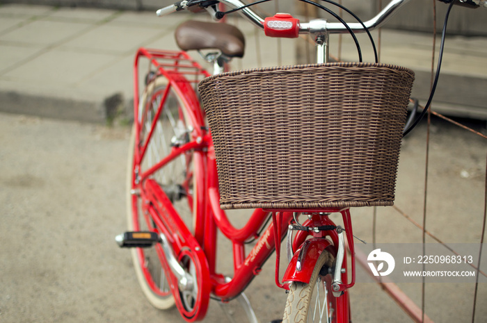 户外红色复古城市自行车车把上的棕色篮子的特写。骗局