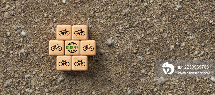 cubes with bike symbols and message GO GREEN on dirt gravel background