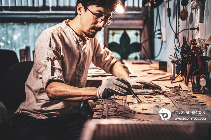 Pensive craftman is restoring ancient broken stained glass at his own workplace.