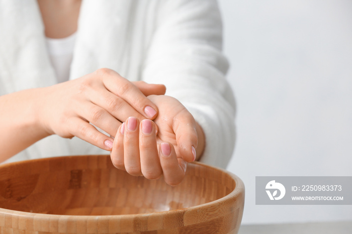 Young woman undergoing spa manicure treatment in beauty salon