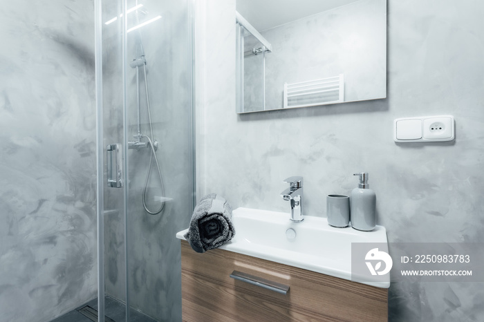 带淋浴和水槽的现代浴室，下面有木制橱柜和带集成l的镜子