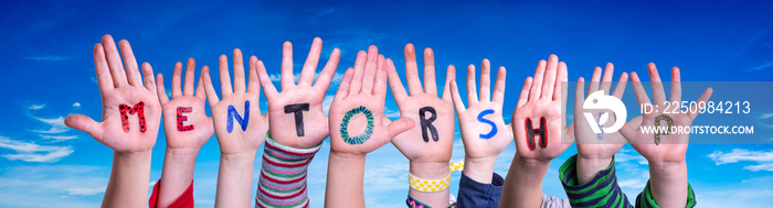 Children Hands Building Colorful English Word Mentorship. Blue Sky As Background