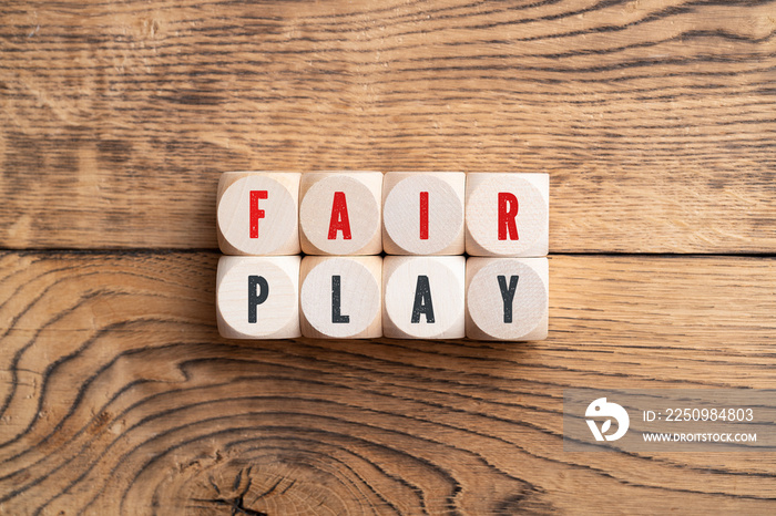 cubes showing the message  fair play  on wooden background