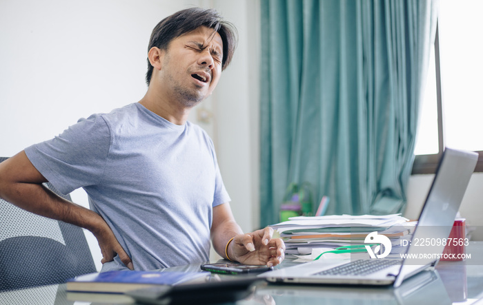 Young Asian office worker suffering from back pain in office , Office syndrome