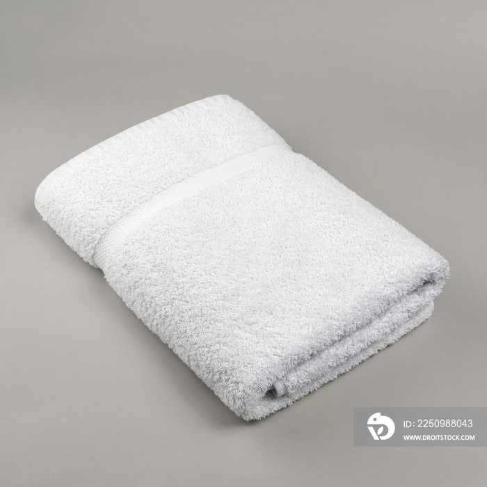 Neat folded fluffy fresh white towel on gray background