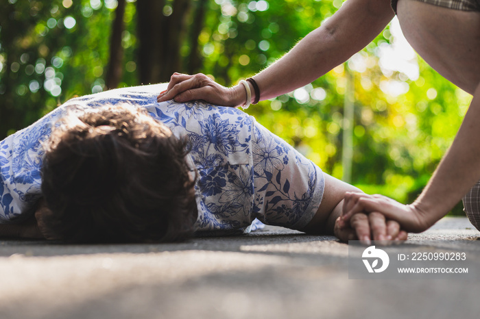 Old woman fell on the ground – Elder lying on the street while a teenager is checking up on her