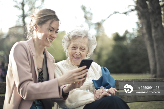 年轻女性向老年女性解释如何使用智能手机