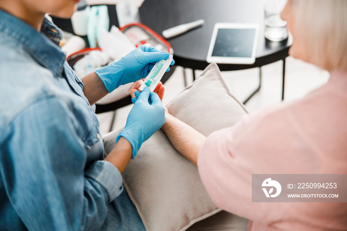 Female doctor hands in sterile gloves holding syringe