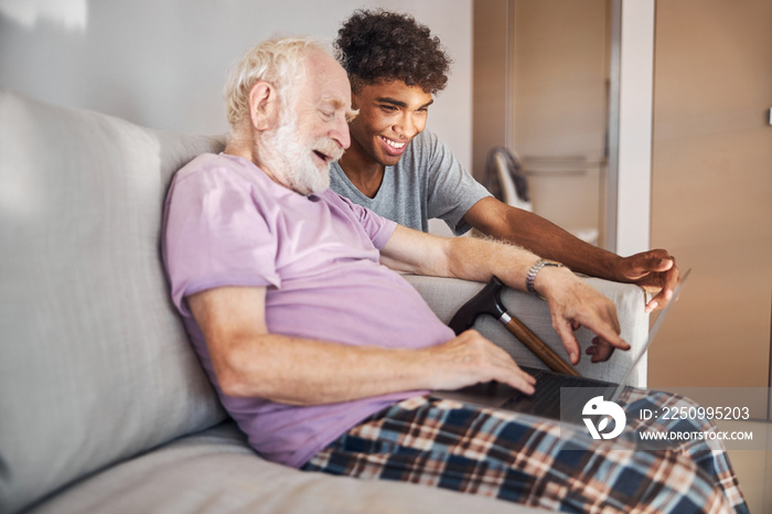 Pensioner and his caregiver looking at the computer