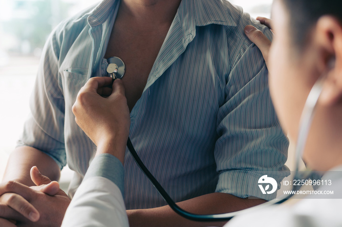 Asian doctor is using a stethoscope listen to the heartbeat of the elderly patient.