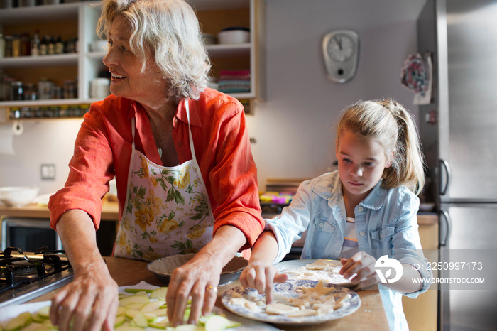 Girl (6-7) making cookies with grandmother