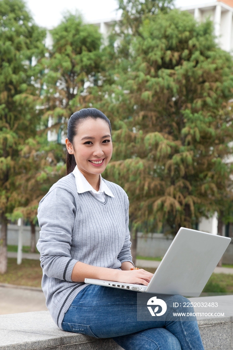 年轻大学生在校园里使用笔记本电脑