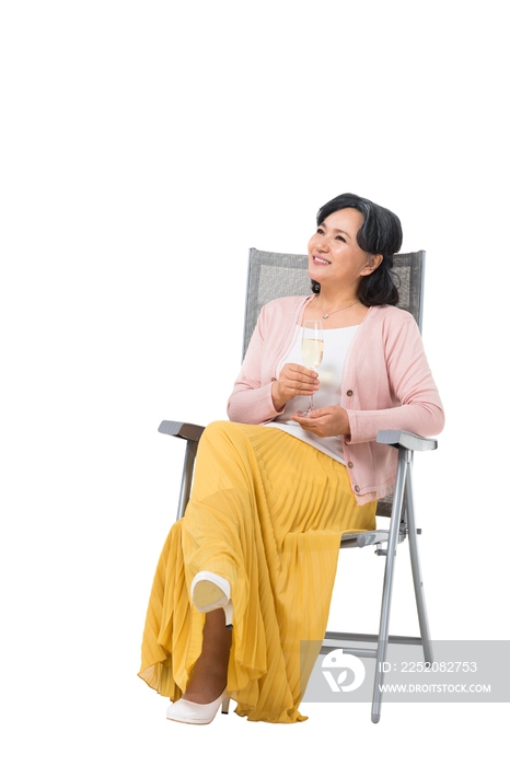 中老年女人坐在沙滩椅上喝香槟酒