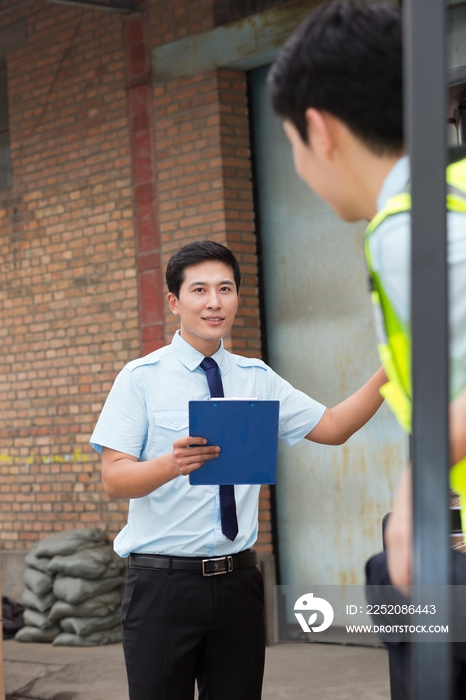 物流仓库管理人员与驾驶叉车的工人沟通