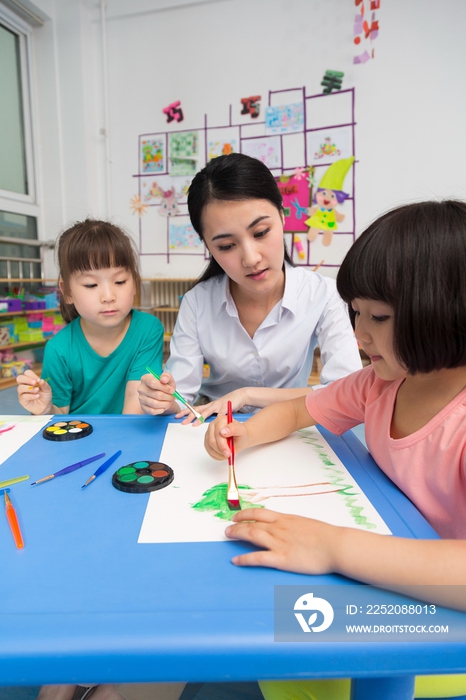 幼儿园女老师辅导儿童画画