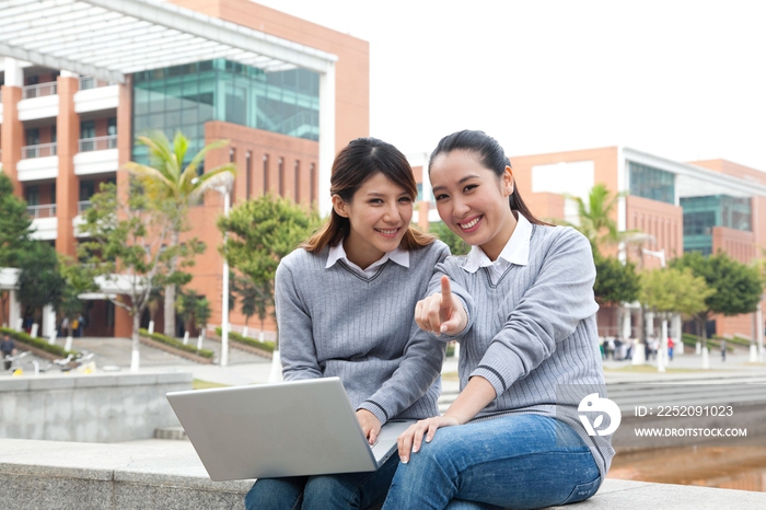 年轻大学生在校园里使用笔记本电脑