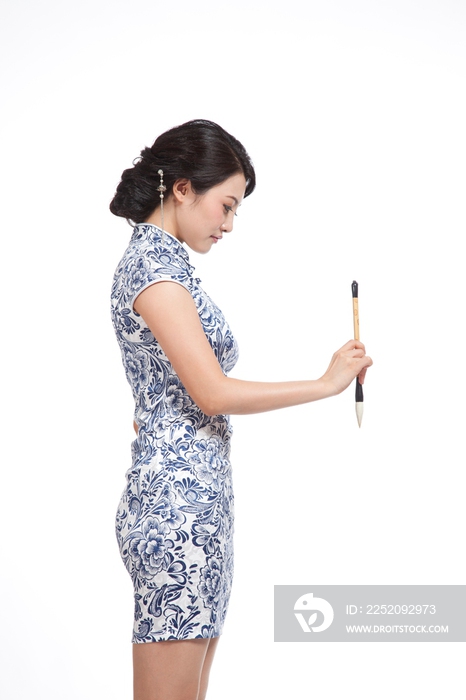 棚拍身穿中国传统服装的年轻女人和毛笔