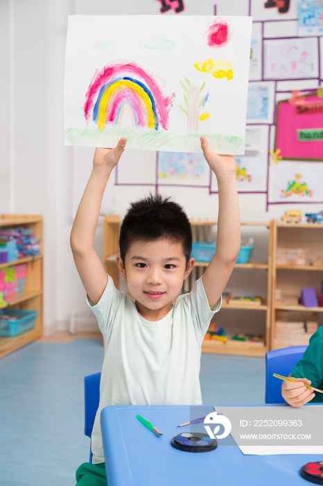 幼儿园女老师和儿童展示绘画作品