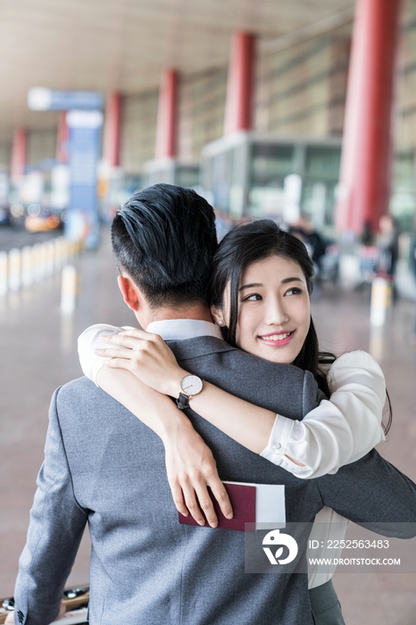 年轻情侣在机场团聚拥抱