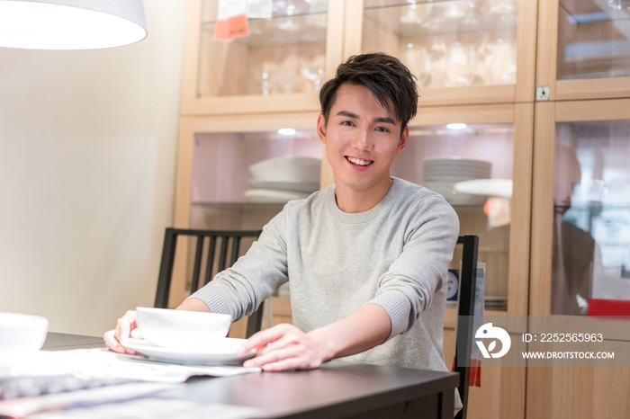 年轻男子坐在餐桌旁