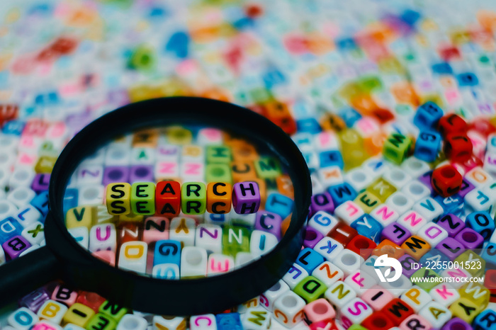 Word  SEARCH  on the magnifying glass with alphabet letter beads background, Search engine optimizat