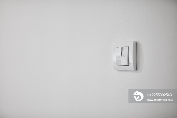 Modern light switch on a white wall.