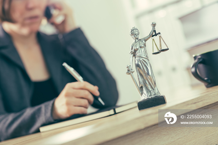 Attorney woman talking on mobile phone from her office desk