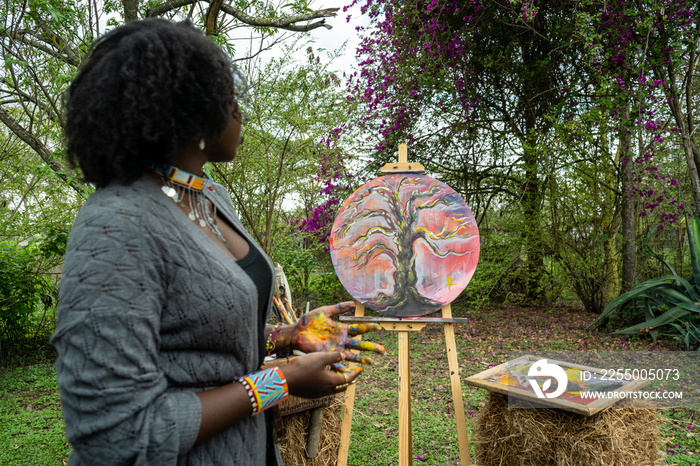 young female artist proudly displaying her work