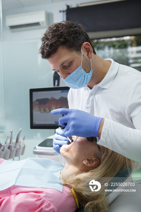 Vertical shot of a dentist doing dental scan of patients teeth