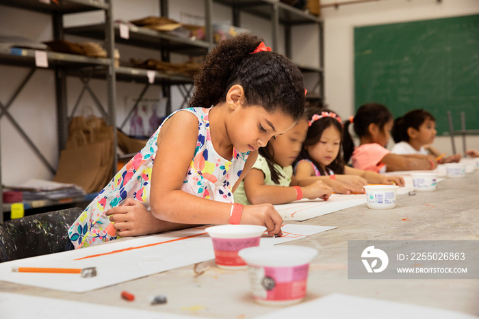 Young girl drawing in a classroom