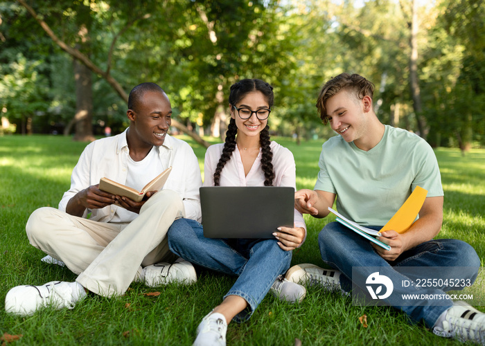 快乐的多种族学生交谈和使用笔记本电脑，在大学校园休息，免费水疗