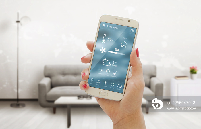 手机应用程序上的家庭温度、安全和环境控制。女性手中的智能手机。Living ro