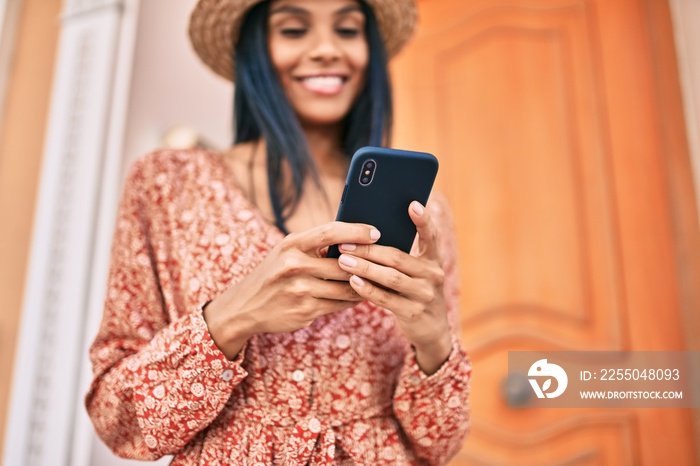 Young african american tourist woman on vacation smiling happy using smartphone at the city.