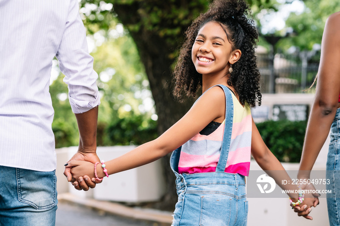 Little girl enjoying a walk outdoors with her parents.