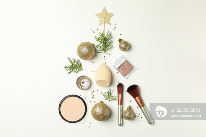 Christmas tree made of cosmetics and baubles on white background