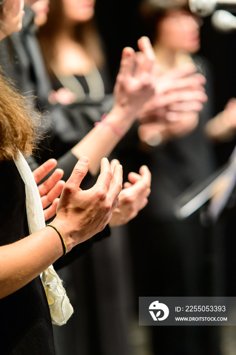 Mani di coriste che battono il tempo musicale, fuoco selettivo