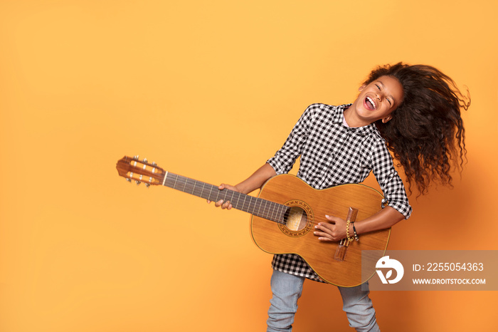 非洲裔美国少女弹吉他。
