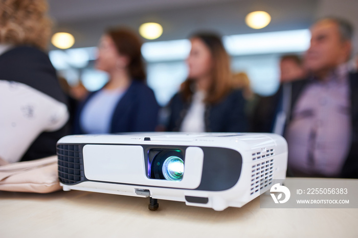 Working projector at the conference hall. Blurred people at background.