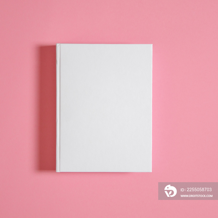 Mockup of closed blank square book at white textured paper