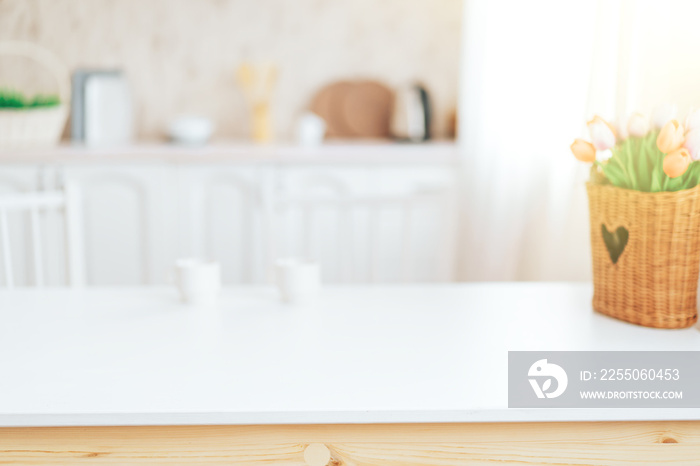 Wooden table with grass in front of blurred kitchen.