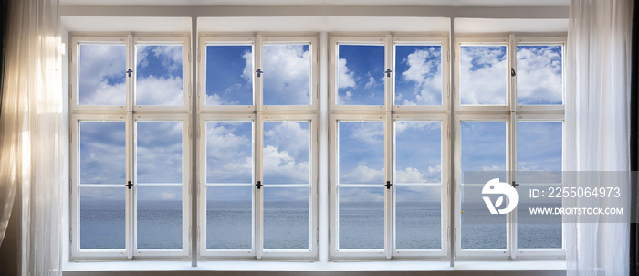 View of calm sea and blue sky background through old window concept. Retro white window